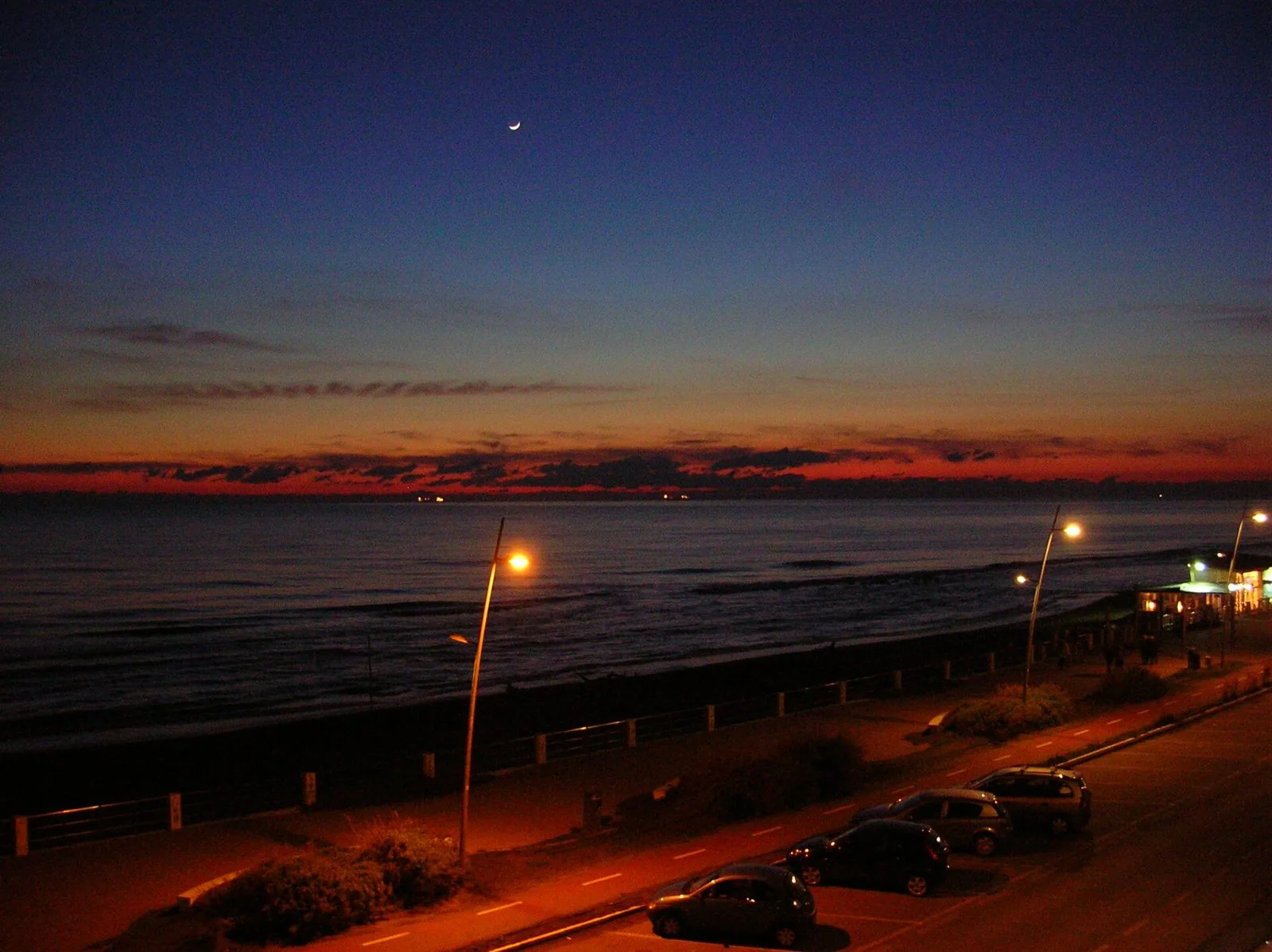 Il lungomare Duca degli Abruzzi di Ostia al crepuscolo d'inverno, con i lampioni accesi e il mare calmo